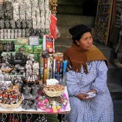 Una bruja, seduta fuori la sua bancarella al Mercato delle Streghe